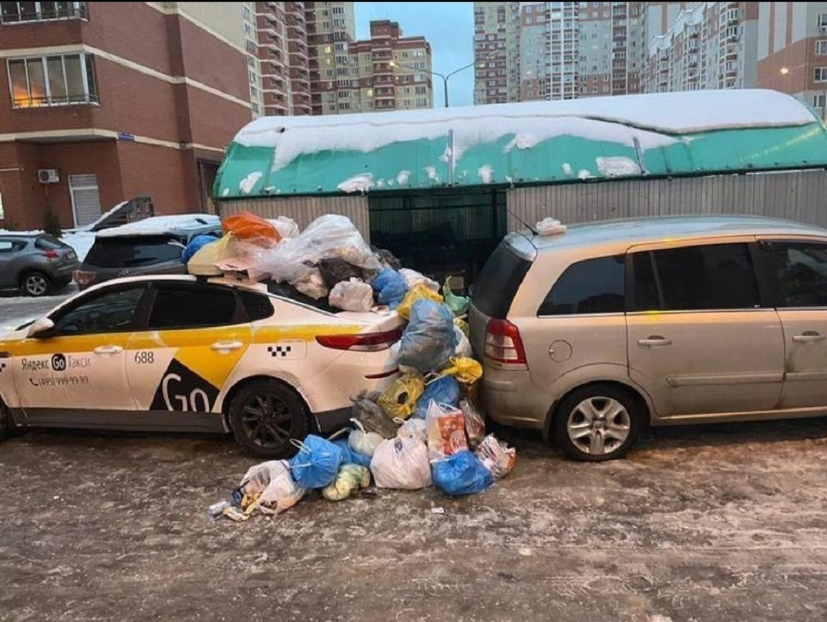 Жители Балашихи завалили мусором такси, загородившее контейнерную площадку